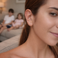 Femme appliquant des ear seeds Ora Healing sur l'oreille, ambiance famille