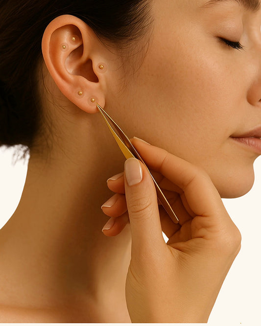 Kit Féminin Ora : application d'une graine auriculaire dorée sur l'oreille